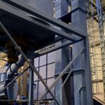 Eimerbeschicker zum Transport von Sägemehl zu einem Tank mit Mischer