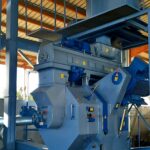 Granulator zum Granulieren von Sägemehl mit Aufbereiter, Zuführung zum Transport von Pellets und Puffertank mit Mischer über dem Granulator